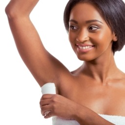 Pretty African American woman putting on deodorant