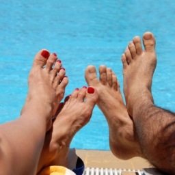 Man and woman feet by poolside